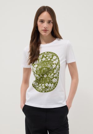 Young woman with long brown hair wearing a white t-shirt with a green floral design and the text "Choose only one master nature."