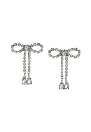 Silver earrings featuring bow design with clear crystal accents, hanging chains, and teardrop-shaped gemstones at the bottom.
