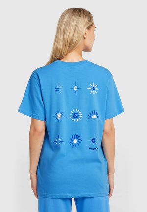 Blauw katoenen T-shirt met een gedrukte afbeelding van zonnen en manen op de achterkant in verschillende tinten blauw en wit. Korte mouwen, relaxte pasvorm.