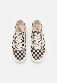 Schwarz-weiß karierten Canvas-Sneaker mit weißen Schnürsenkeln, abgerundeter Zehenpartie und flacher Gummisohle. Enthält ein Vans-Logo auf der Innensohle.
