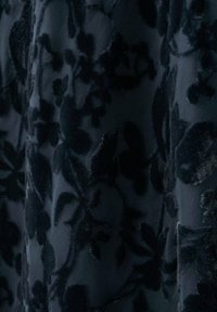 Donkere stof met verhoogde fluwelen bloemmotieven in diepzwart, met een gestructureerd en elegant ontwerp.