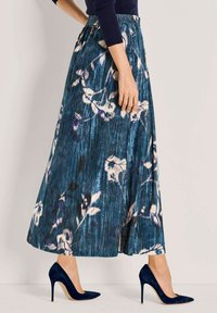 Bloemrijke maxi-rok in blauw, met een geplooid ontwerp, een elastische tailleband en een vloeiende silhout. Gecombineerd met navy hoge hakken.