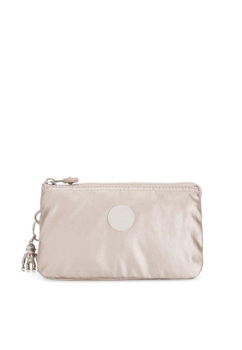 Beige satinpung med en tekstureret overflade, lynlåslukning, cirkulært logo-patch og en dekorativ charm fastgjort til lynlåsen.