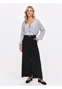 Szara, długosleeve koszula z guzikami w serek; czarne, szerokie spodnie z pasującym paskiem; czarne baleriny; jednolite kolory, casualowy styl.