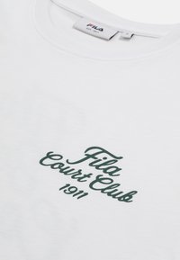 T-shirt blanc col rond avec l’inscription "Fila Court Club 1911" en écriture verte foncée sur le devant et une petite étiquette Fila sur le col.