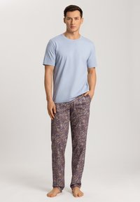 Svetle modré bavlněné tričko v kombinaci s fialovými pyžamovými kalhotami s vzorem paisley. Měkká textura, volný střih a dlouhá délka.