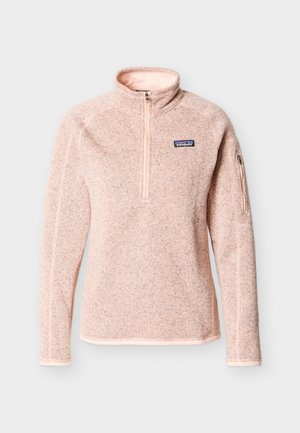 Heleheledat roosa neljandiku tõmblukuga fliisülikond, pikkade varrukatega, kõrge kraega, väike tõmblukuga tasku vasakul varrukal ja Patagonia logo vasakul rinnal.