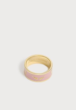 Bague large dorée et rose avec de petits motifs d'ailes dorées et texte gravé à l'intérieur de la bague sur fond blanc.