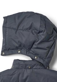 Mörkblå vadderad jackhuva med quiltad struktur, tryckknappar och ett kardborreband som detalj. Rundad form upptill.