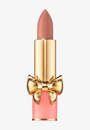Lipstick with a pink and gold tube, featuring a textured gold bow accent. The bullet is a soft nude color with a pointed tip.