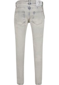 Világosszürke farmernadrág, slim fit fazonnal, két hátsó zsebbel és egy kis láncrészlettel a deréknál. Sima textúra, minimális kopás.