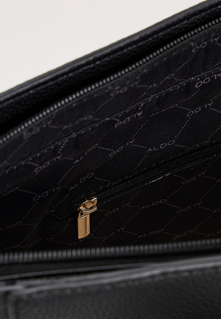 Interior de un bolso negro con un forro suave y texturizado y un bolsillo con cremallera. Patrón sutil del logo "ALDO" en la tela. Bordes resistentes, cosidos.