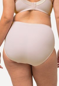Lichtbeige high-waisted slip gemaakt van gladde stof. Kenmerkt zich door een zachte tailleband en naadloze randen voor comfort en een discreet uiterlijk.