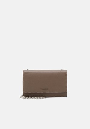 Bolso bandolera compacto de piel taupe con cierre de solapa y correa de cadena plateada, enrollado delante.