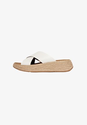Witte leren slipper met kruisbanden, jute platformzool en een tan rubberen onderkant. Het ontwerp is minimalistisch en modern.