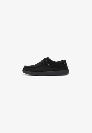 Chaussures noires à enfiler, fabriquées en tissu souple, avec un bout rond, une semelle en caoutchouc noir texturé et un laçage ajustable pour un maintien sûr.