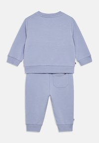 Conjunto de sudadera y pantalones de chándal para niños en color púrpura claro de algodón. Puños y dobladillo acanalados, con un pequeño detalle de bolsillo en la parte trasera de los pantalones.