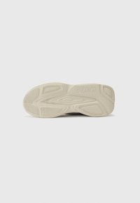 Rubber shoe sole in cream color featuring a textured pattern with grooves and branding. Designed for grip and durability.