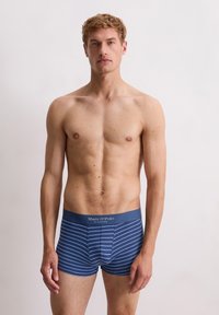 Boxer ajustados de hombre en azul a rayas, fabricados en algodón suave. Presentan una cinturilla elástica y rayas horizontales en diferentes tonos de azul.