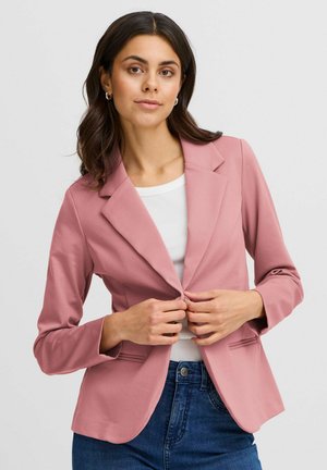 Svetloružový blazer s olemovaným golierom, s gombíkovým zapínaním a dvomi prednými vreckami. Hladká textúra, dlhé rukávy, skombinovaný s bielym topom.