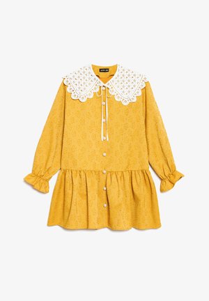 Vestido amarillo con mangas largas, textura floral con ojales, cuello de encaje blanco con borde ondulado, botones de perla en la parte delantera y puños y dobladillo con volantes.