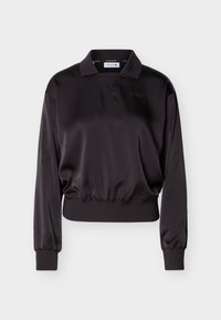 Polo en satin noir à manches longues avec poignets et ourlet côtelés, présentant un logo brodé subtil sur la poitrine.