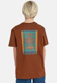 Braunes Baumwoll-T-Shirt mit einem bunten Grafikdesign auf der Rückseite, das Meereskreaturen in einem rechteckigen Muster mit Text darstellt.