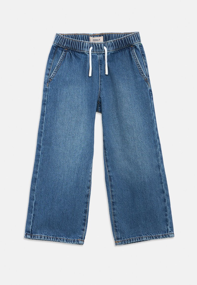 Calças largas de ganga azul com cintura elástica, fecho com cordão e dois bolsos laterais. O tecido tem uma textura suave com manchas desbotadas.