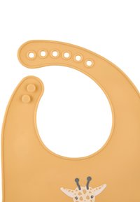 Silikon-Lätzchen in sanftem Orange mit einem Giraffenmotiv. Verfügt über eine große Halsöffnung mit mehreren Druckknopf-Einstellungen und einer strukturierten Oberfläche.