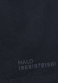 Tissu noir présentant une surface texturée avec un texte imprimé "HALO 196819721981" dans une nuance contrastante, positionné en bas.