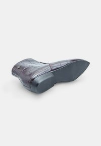 Burgundy faux leather block-heel shoe with a crocodile texture, rounded toe, and a rubber outsole for traction. Features a small emblem detail.