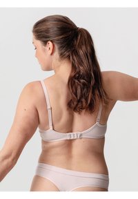 Hellbeige BH mit verstellbaren Trägern, glatter Textur und Haken- und Ösenverschluss auf der Rückseite. Minimalistisches Design, ohne Muster oder Akzente.