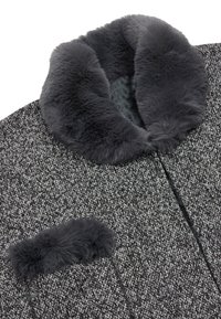 Grijze textuur jas met een zachte grijze faux fur kraag en een bijpassende faux fur zakaccent. Heeft een rechte snit en geen zichtbare knopen.
