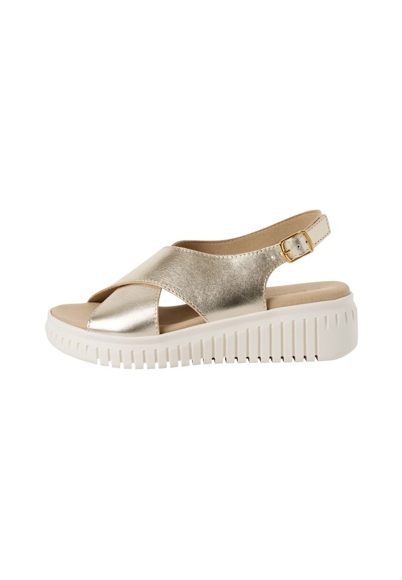 Sandale métallique dorée avec des brides croisées, design à talon ouvert, et une semelle blanche à plate-forme avec une texture striée.