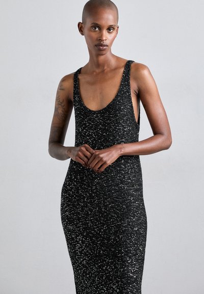 Rochie neagră fără mâneci, cu decolteu rotund, având un model texturat, strălucitor din tricot, siluetă ajustată și laterale deschise.