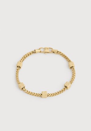 Gold chain bracelet with five small cube-shaped charms evenly spaced and a secure clasp on a plain background.
