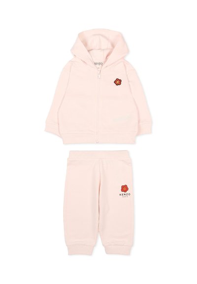 Jasnoróżowy komplet dla malucha z kapturem i spodniami z czerwonymi naszywkami kwiatowymi oraz logo Kenzo Paris na spodniach, bluza zapinana na zamek.