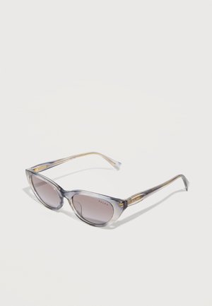 Átlátszó szürke macskaszem napszemüveg gradiens színezésű lencsékkel és arany "Ralph" márkajelzéssel a szárakon, fehér háttér előtt bemutatva.