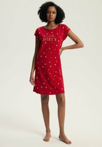 Czerwona nocna sukienka na krótki rękaw z złotym napisem "To powód, by być WESOŁYM", z rombowymi wzorami rozrzuconymi po całej powierzchni. Miękka tkanina.