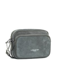 Borsa a tracolla rettangolare in suede grigio con due scomparti con zip, hardware in argento e logo "Lancaster Paris" sulla tasca anteriore.