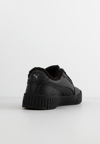 Czarne sneakersy z teksturowanej skórzanej cholewki i wyściółką z futra. Posiadają żłobioną gumową podeszwę oraz logo na pięcie.