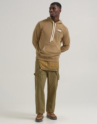 Hoodie marrone con coulisse regolabili e tasca frontale, abbinato a pantaloni in corduroy verde oliva con bottoni laterali e tasca frontale.