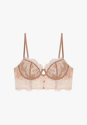 Soutien-gorge en dentelle et satin beige avec un overlay en dentelle semi-transparente, bonnets à armatures, détail décoratif avec bouton, et bretelles ajustables.