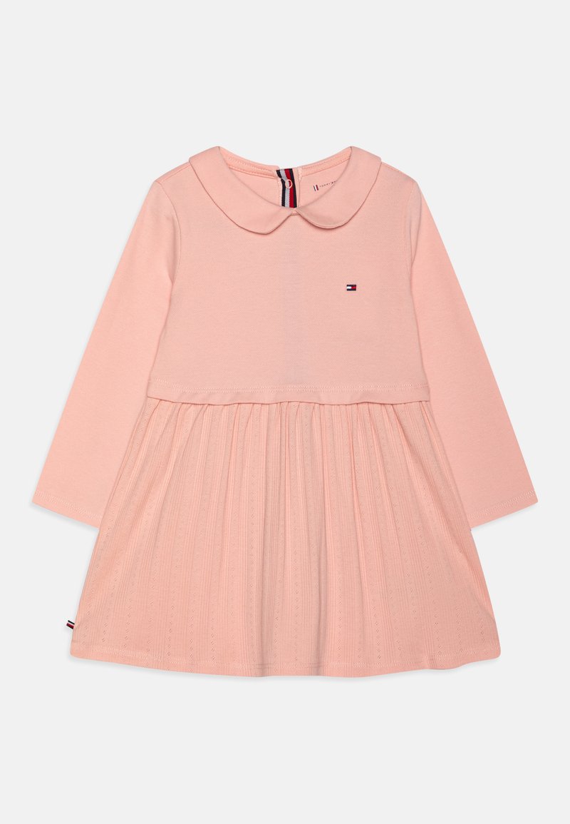 Vestido rosa de manga larga con cuello, que presenta una falda plisada. La tela tiene un patrón texturizado y un pequeño logo está exhibido en el pecho.