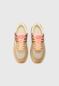 Sneaker beige e marroni con tessuto a rete, accenti rosa e lacci gialli. Forma arrotondata con sovrapposizioni testurizzate e logo sulla linguetta.