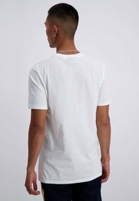 T-shirt bianca in cotone con maniche corte e scollatura rotonda, presenta una texture liscia e un taglio dritto all'orlo.