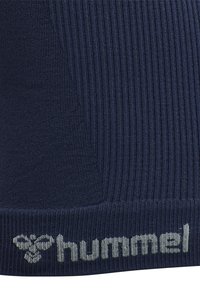 Dark blue ribbed fabric with gray "hummel" text and stylized bee logo knitted near the bottom edge.