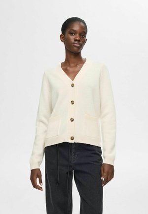Cremefarbener Strickcardigan mit V-Ausschnitt, fünf großen Knöpfen und zwei vorderen Taschen. Gerippte Bündchen und Saum, aus weichem Stoff gefertigt.