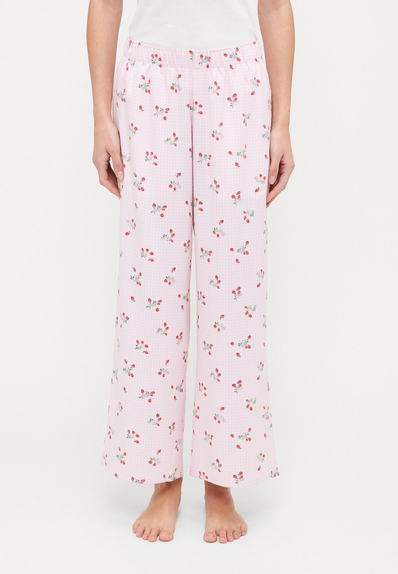 Pantaloni da pigiama leggeri rosa con un motivo a quadri e piccoli fiori rossi e foglie verdi. Vita elastica, gambe larghe.