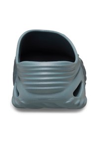 Blauer, geformter Schlupfschuh mit strukturierter Oberfläche, glatten Kanten und seitlichen Belüftungslöchern. Abgerundete Rückseite und offenes Design.